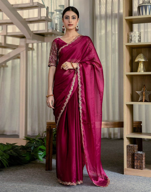 A woman wearing a deep pink Graceful Rangoli Fabric Saree with a neat finish and comfortable drape, paired with matching embroidered blouse and elegant jewelry.